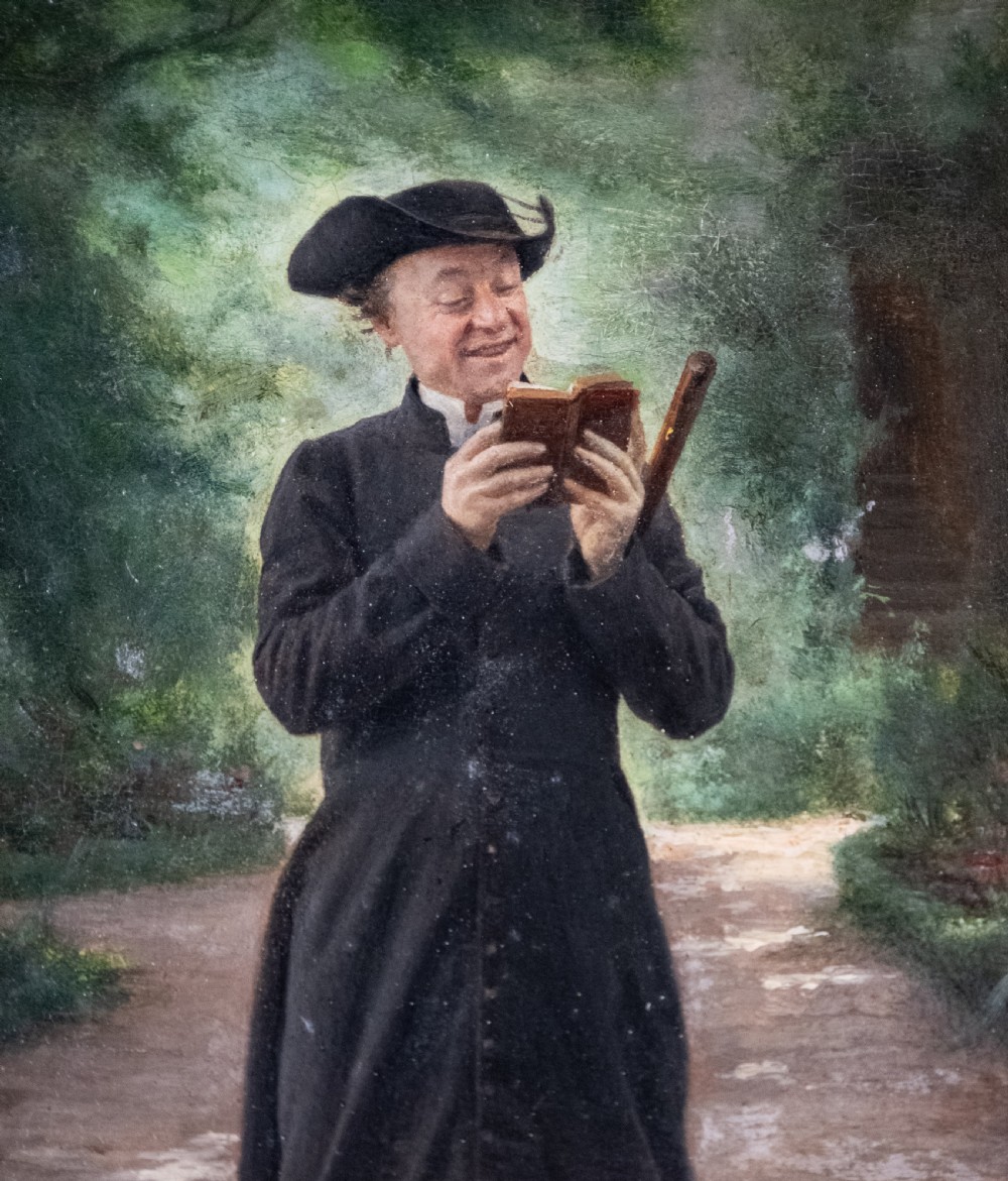 A 19th-century oil painting on panel depicting a smiling clergyman reading a book, set within a heavily carved rococo gilt frame. View IV