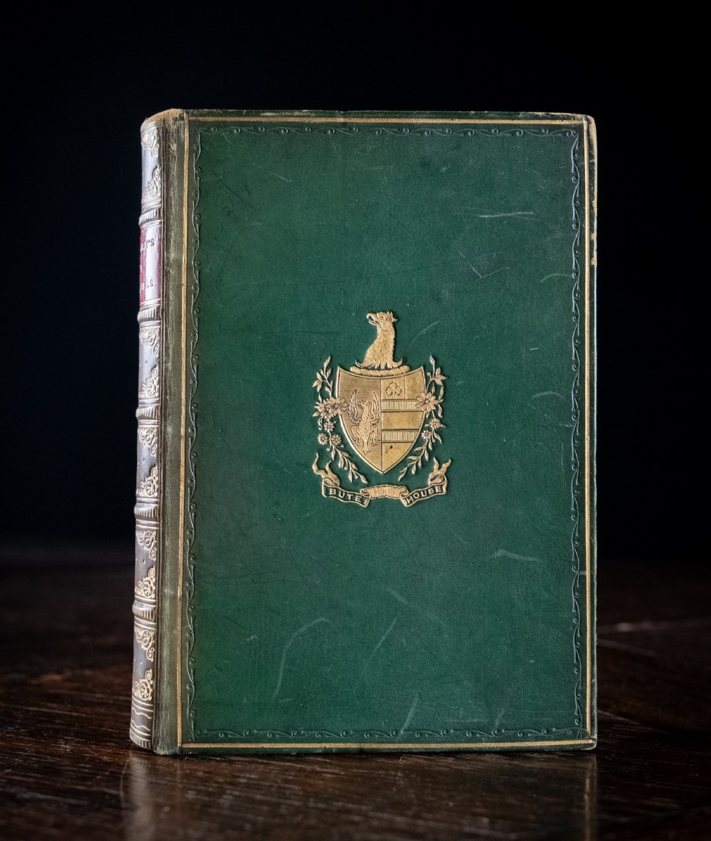 A Victorian leather-bound book standing upright, featuring green boards with a gilt crest and a brown leather spine decorated with gold tooling. View III