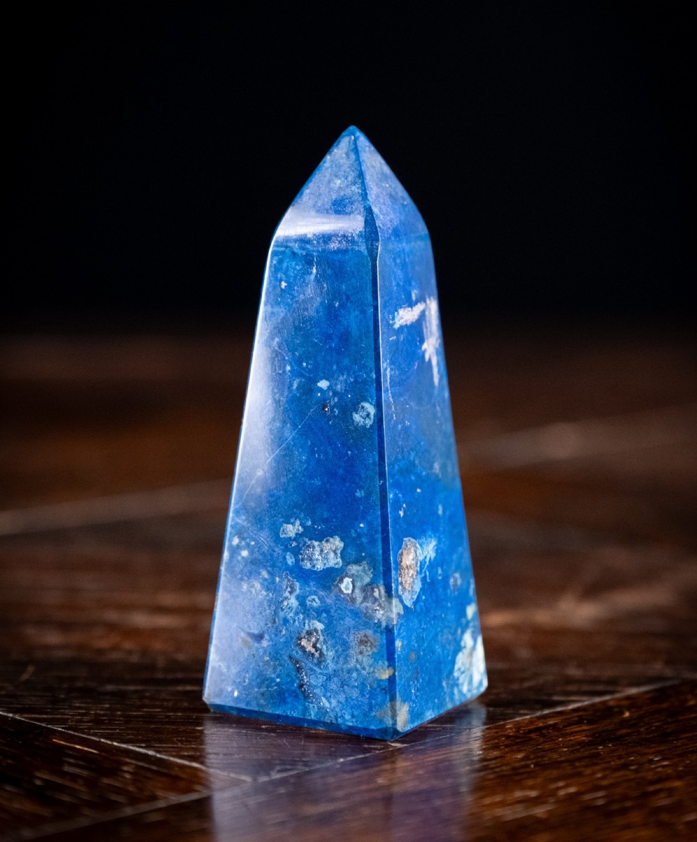 A polished deep blue lapis lazuli obelisk engraved with gilt text reading Interlacken 1876 near the base. View IV