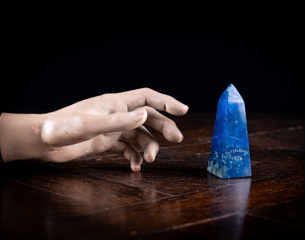 A polished deep blue lapis lazuli obelisk engraved with gilt text reading Interlacken 1876 near the base. View VIII