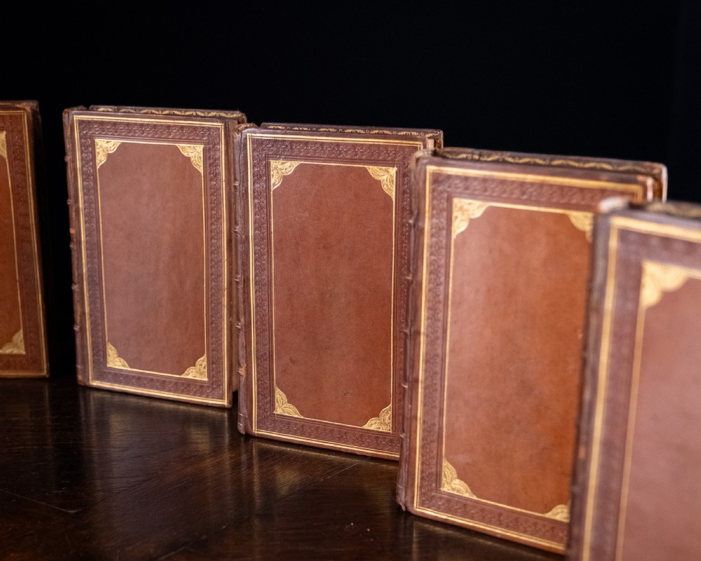 A complete twelve-volume set of brown leather-bound books printed in 1807 with gold-tooled decorative spines. View X