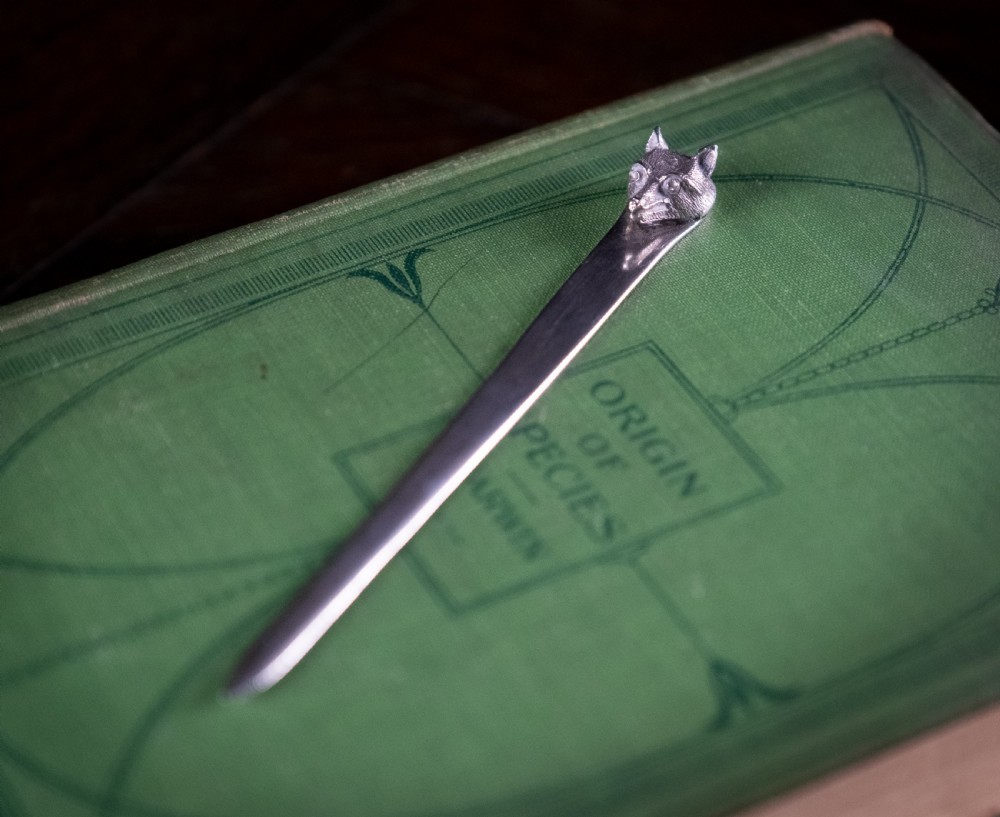 A solid sterling silver letter opener featuring a cast fox head terminal and a tapered flat blade.
