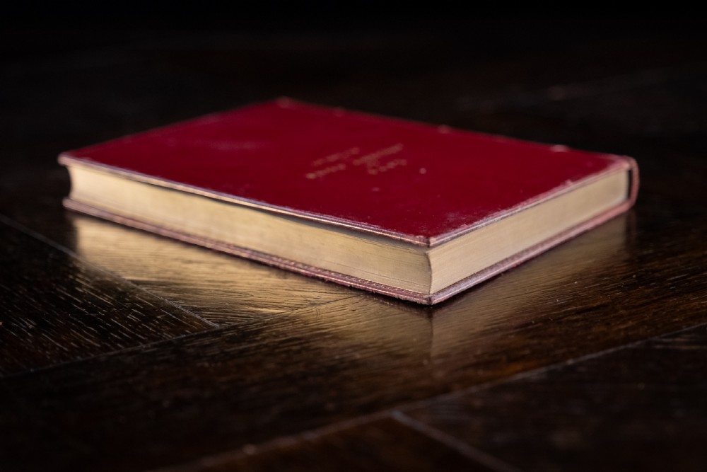A red leather-bound edition of Lays of Ancient Rome by Macaulay, featuring raised spine bands and gilt lettering. View VI