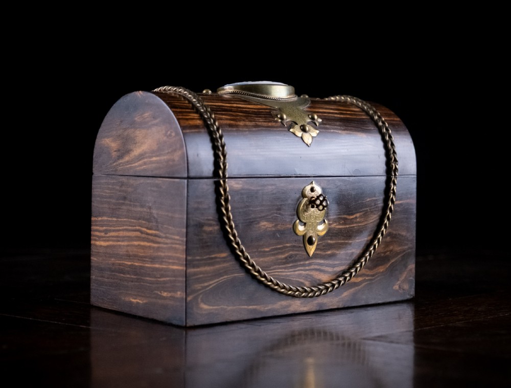 A Victorian domed coromandel wood casket featuring a central blue jasperware cameo medallion set within engraved brass mounts and a twisted brass border. View IV