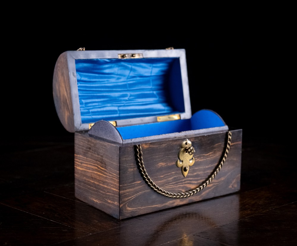 A Victorian domed coromandel wood casket featuring a central blue jasperware cameo medallion set within engraved brass mounts and a twisted brass border. View V