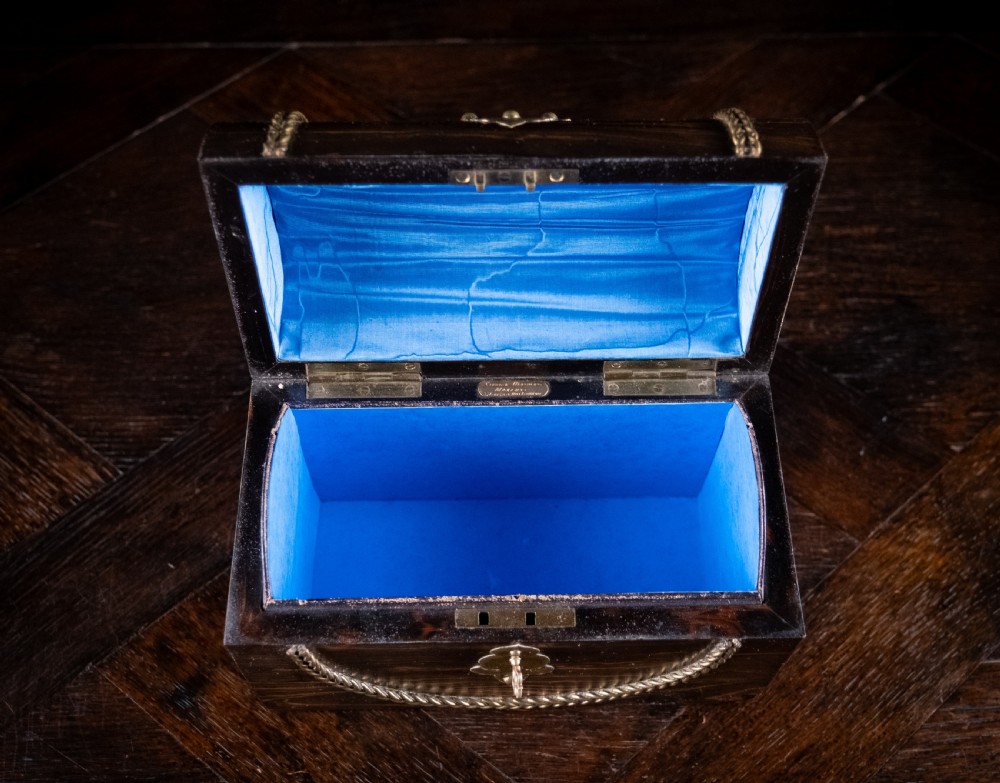 A Victorian domed coromandel wood casket featuring a central blue jasperware cameo medallion set within engraved brass mounts and a twisted brass border. View VI