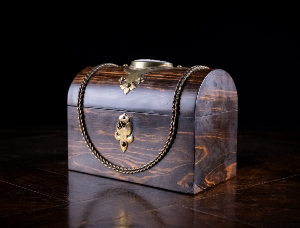 A Victorian domed coromandel wood casket featuring a central blue jasperware cameo medallion set within engraved brass mounts and a twisted brass border. View VIII