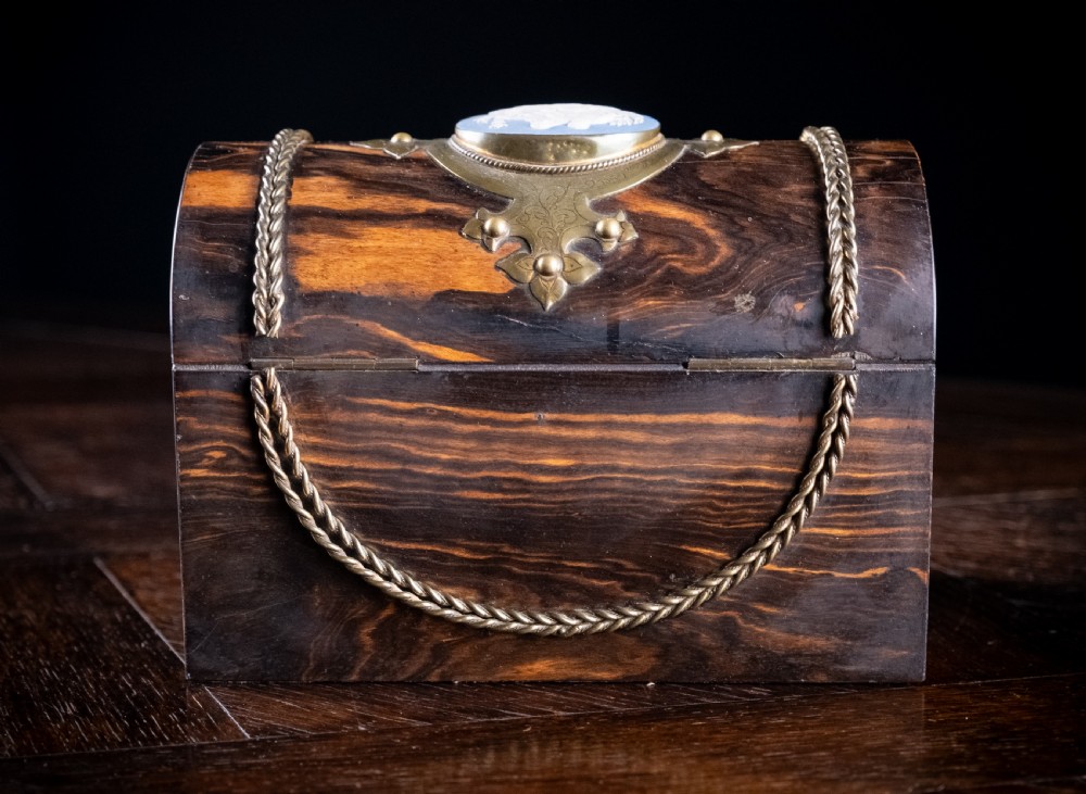 A Victorian domed coromandel wood casket featuring a central blue jasperware cameo medallion set within engraved brass mounts and a twisted brass border. View XI