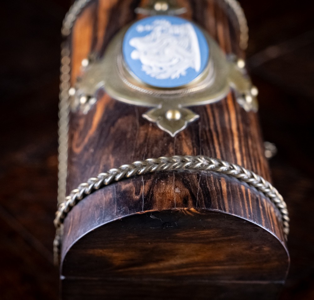 A Victorian domed coromandel wood casket featuring a central blue jasperware cameo medallion set within engraved brass mounts and a twisted brass border. View XIII