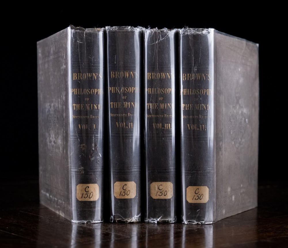 A complete four-volume set of 1846 antique books titled Browns Philosophy of the Mind with gilt lettering on dark grey spines.