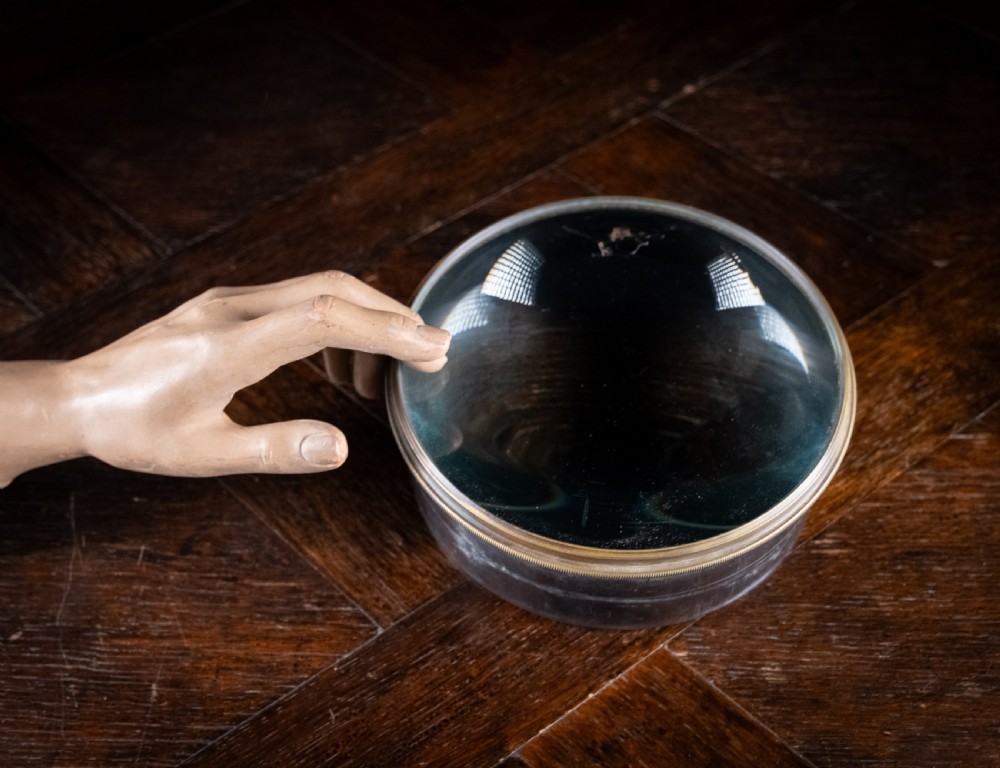 A Victorian cylindrical desktop magnifier featuring a thick circular glass convex lens set within a heavy metal rim. View VI