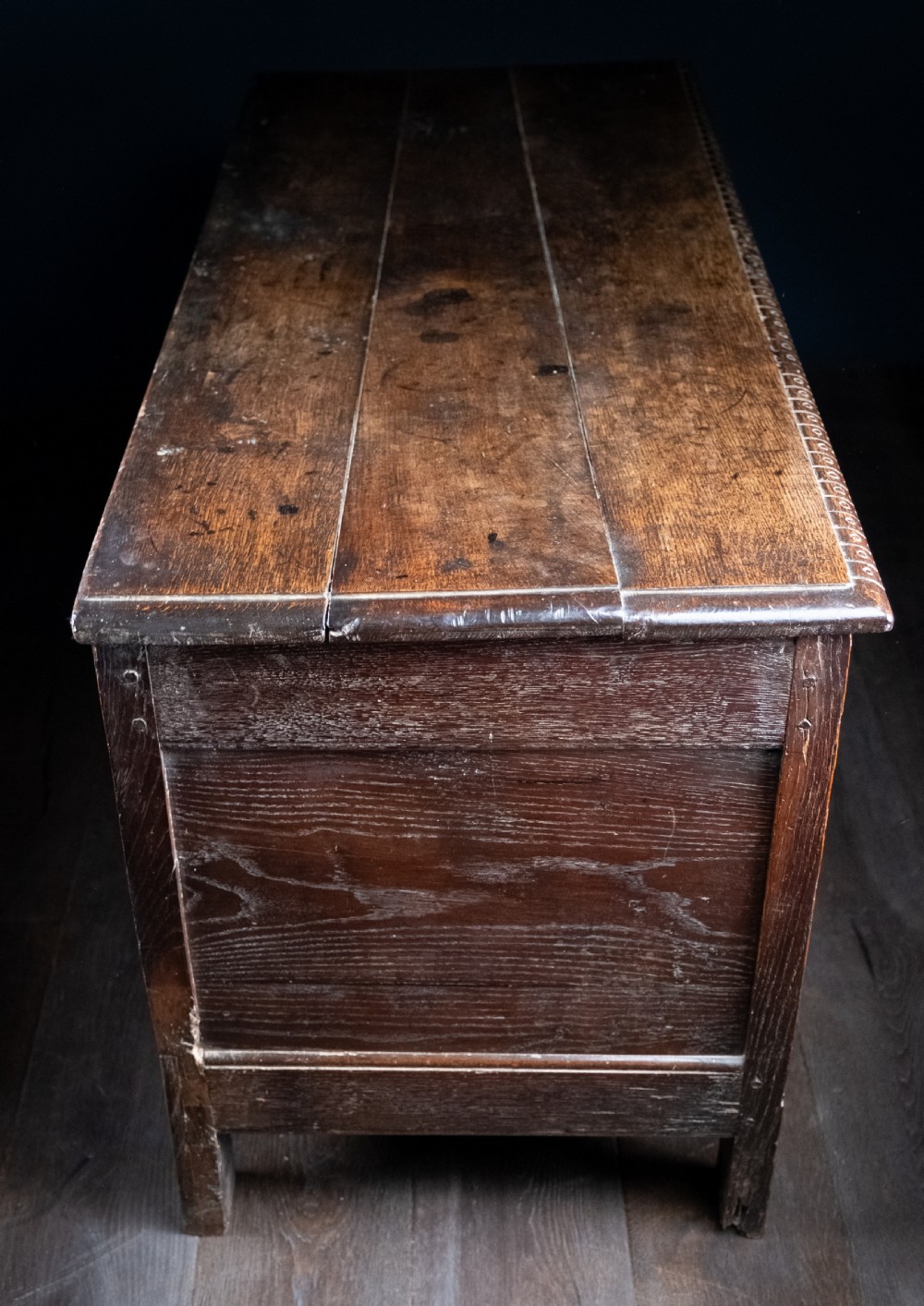 A 17th-century dark oak coffer featuring three carved panels with a central lion motif and geometric rosettes. View XI