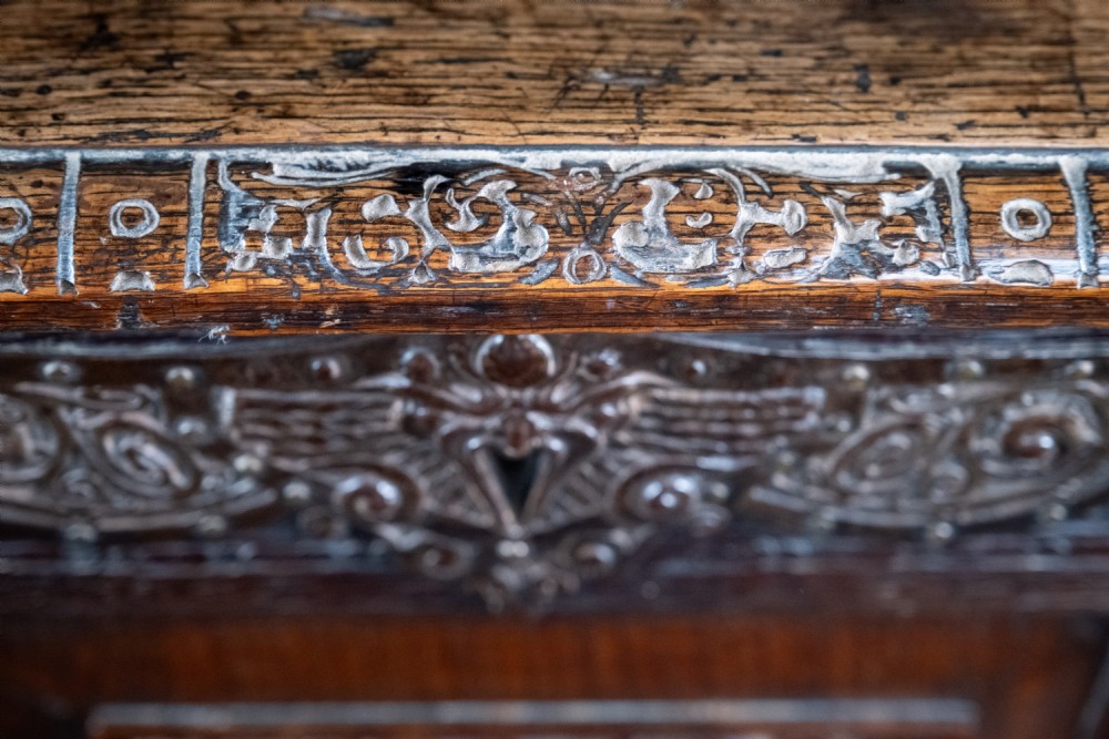 A 17th-century dark oak coffer featuring three carved panels with a central lion motif and geometric rosettes. View XIII