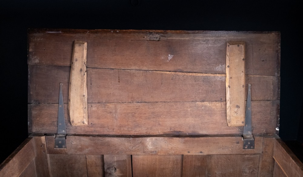 A 17th-century dark oak coffer featuring three carved panels with a central lion motif and geometric rosettes. View XXIII
