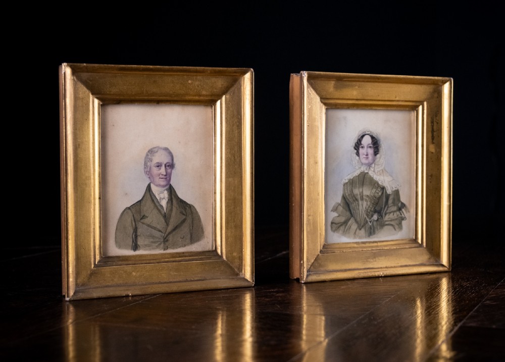 A pair of early 19th-century watercolour portrait paintings featuring a gentleman and a lady set within thick moulded giltwood frames. View V