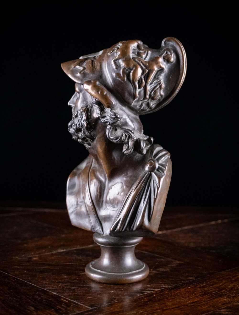 A patinated dark brown French bronze bust depicting the classical figure of Ajax wearing a detailed helmet, set upon a turned circular pedestal. View V