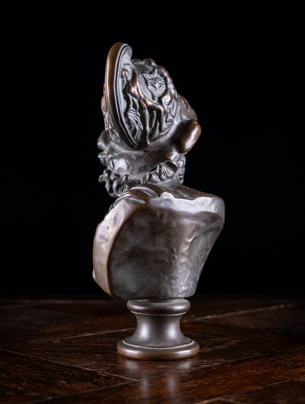 A patinated dark brown French bronze bust depicting the classical figure of Ajax wearing a detailed helmet, set upon a turned circular pedestal. View VI