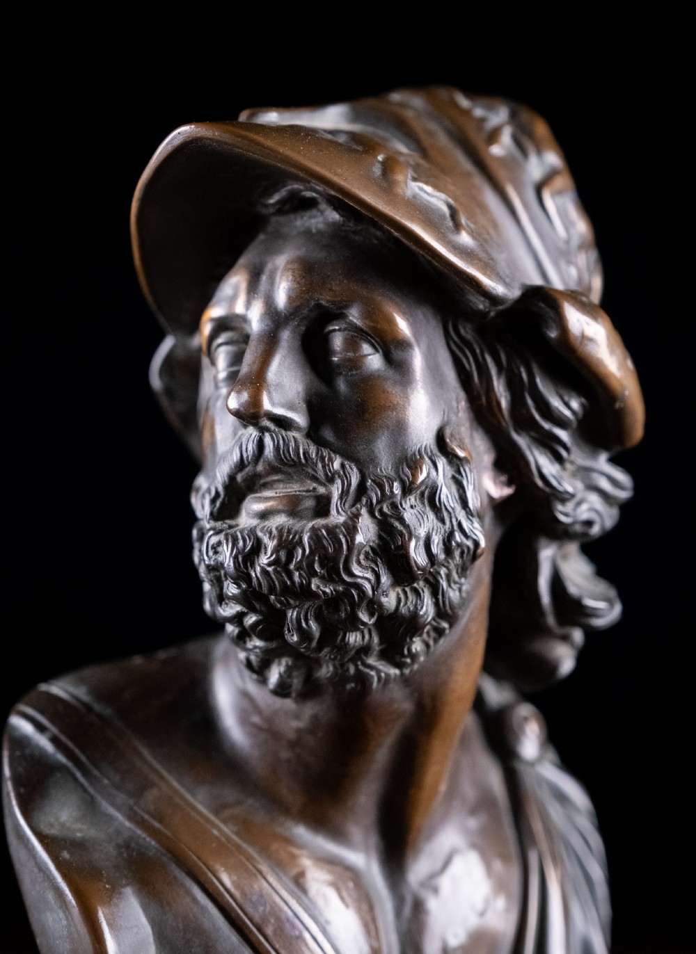 A patinated dark brown French bronze bust depicting the classical figure of Ajax wearing a detailed helmet, set upon a turned circular pedestal. View IX