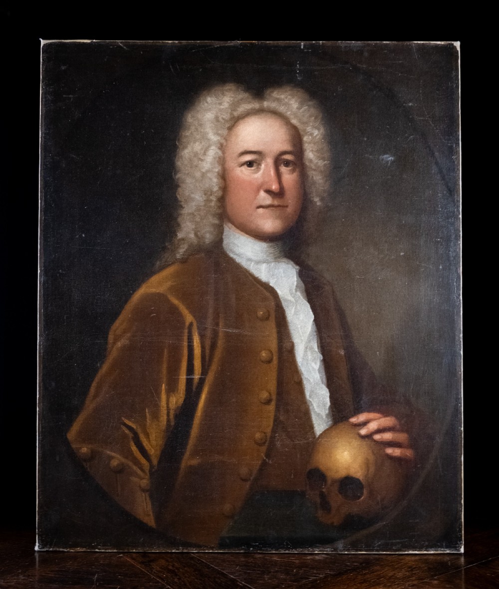 An 18th-century oil painting depicting a gentleman with a white powdered wig wearing a brown coat and resting his hand upon a human skull. View II