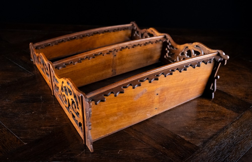 A three-tier Victorian mahogany wall shelf featuring open fretwork sides, pierced scroll decoration, and serrated apron trim. View XII
