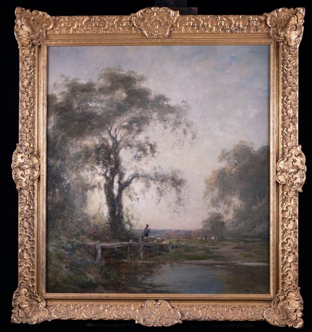 An impressionist oil painting depicting a rural countryside landscape with a large tree by a river, enclosed within an ornate gilded frame.