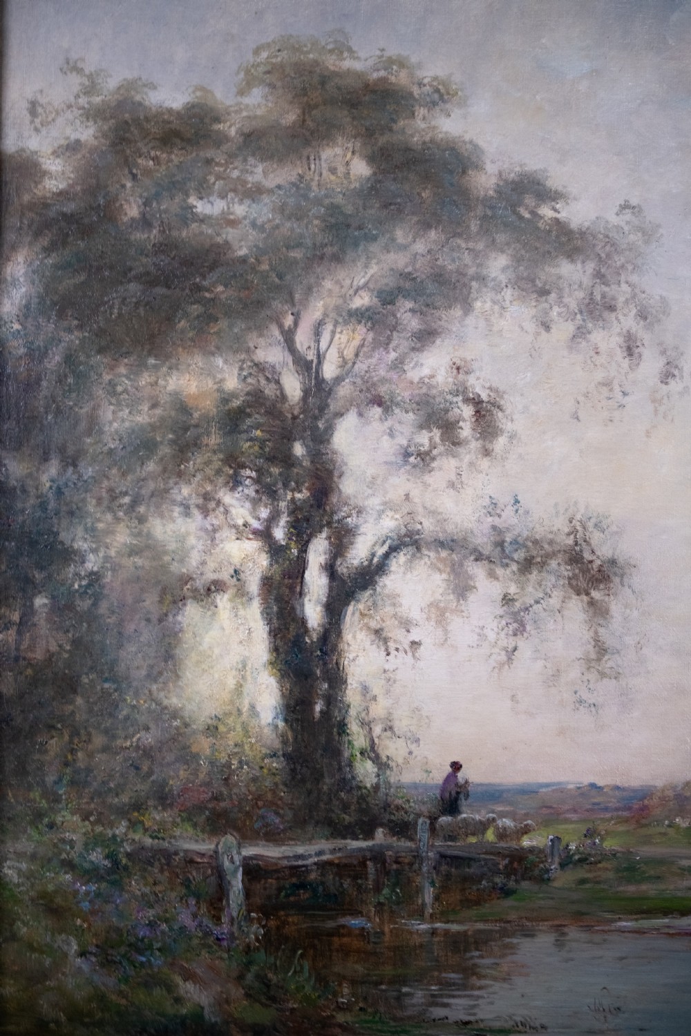An impressionist oil painting depicting a rural countryside landscape with a large tree by a river, enclosed within an ornate gilded frame. View IX