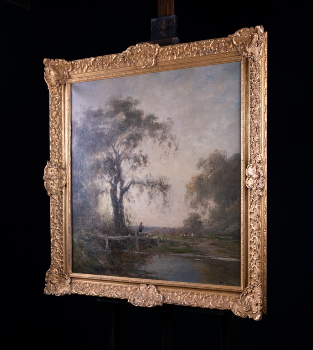 An impressionist oil painting depicting a rural countryside landscape with a large tree by a river, enclosed within an ornate gilded frame. View XII