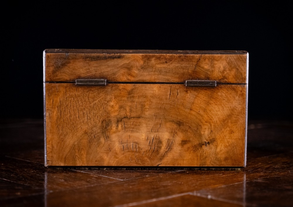 A rectangular walnut tea caddy featuring geometric parquetry borders, a mother-of-pearl escutcheon, and brass inlay on a dark wooden surface. View XV