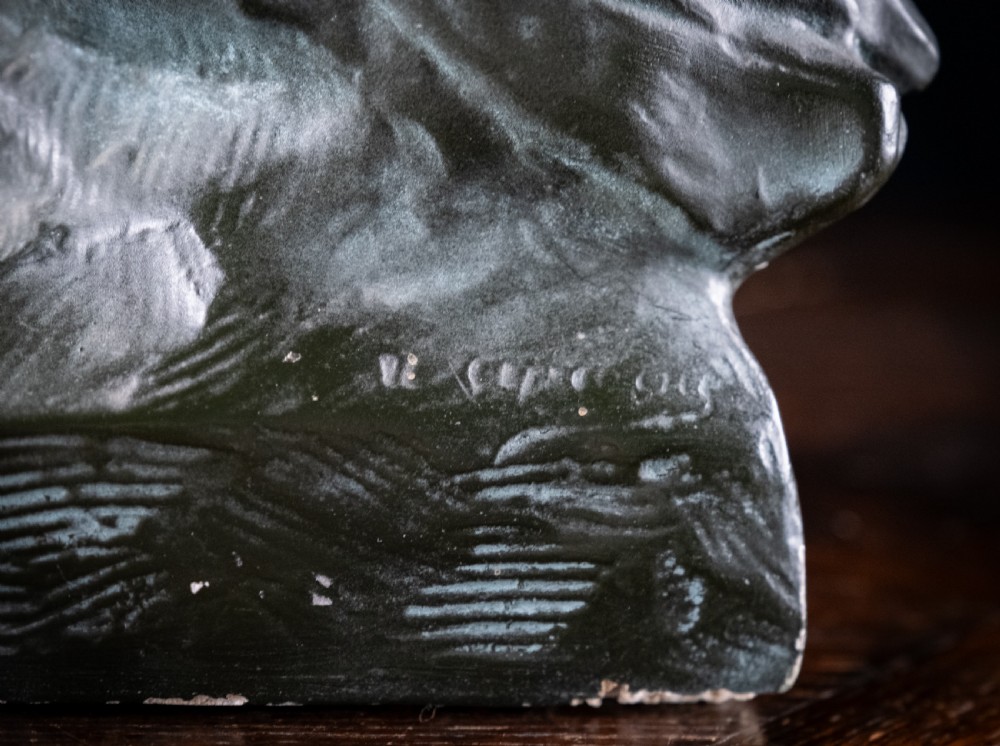 A dark bronze-coloured painted plaster bust depicting composer Ludwig van Beethoven with detailed hair and a dramatic collar on a square base. View IV