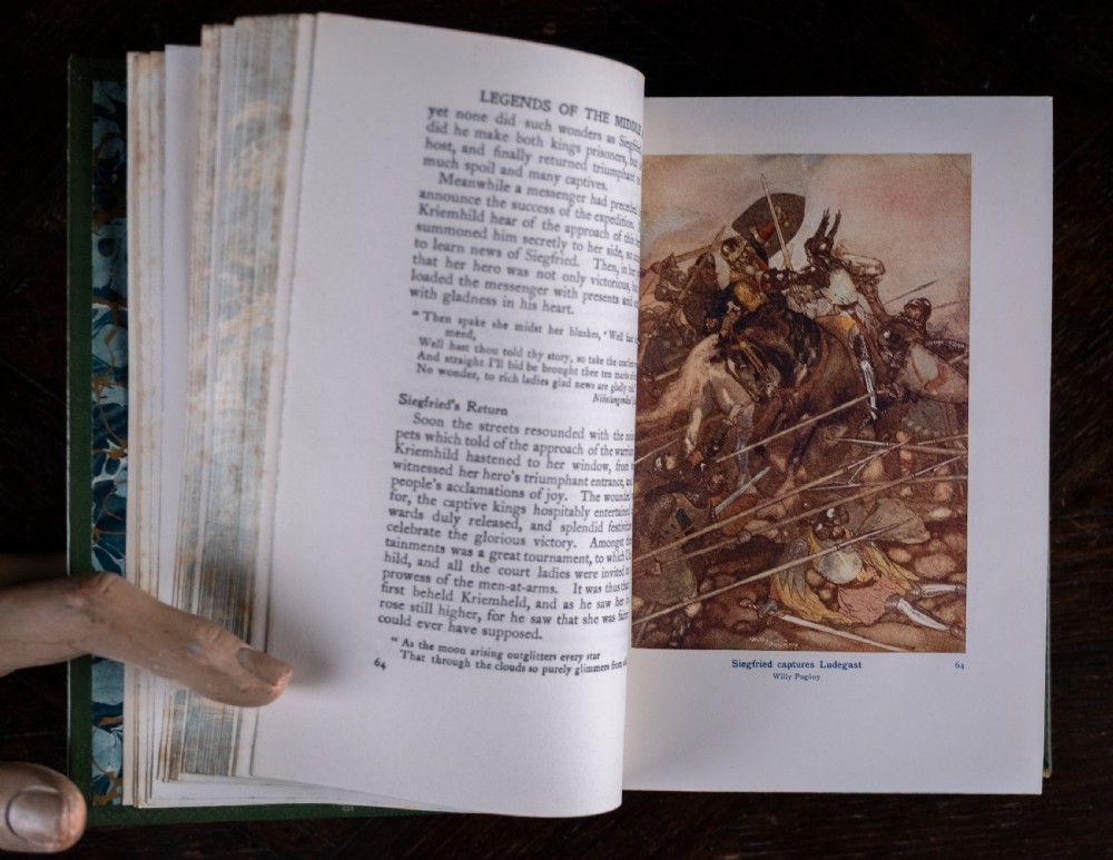 An upright antique book titled Myths and Legends of the Middle Ages with a brown leather spine featuring gilt tooling and green cloth covers. View XV