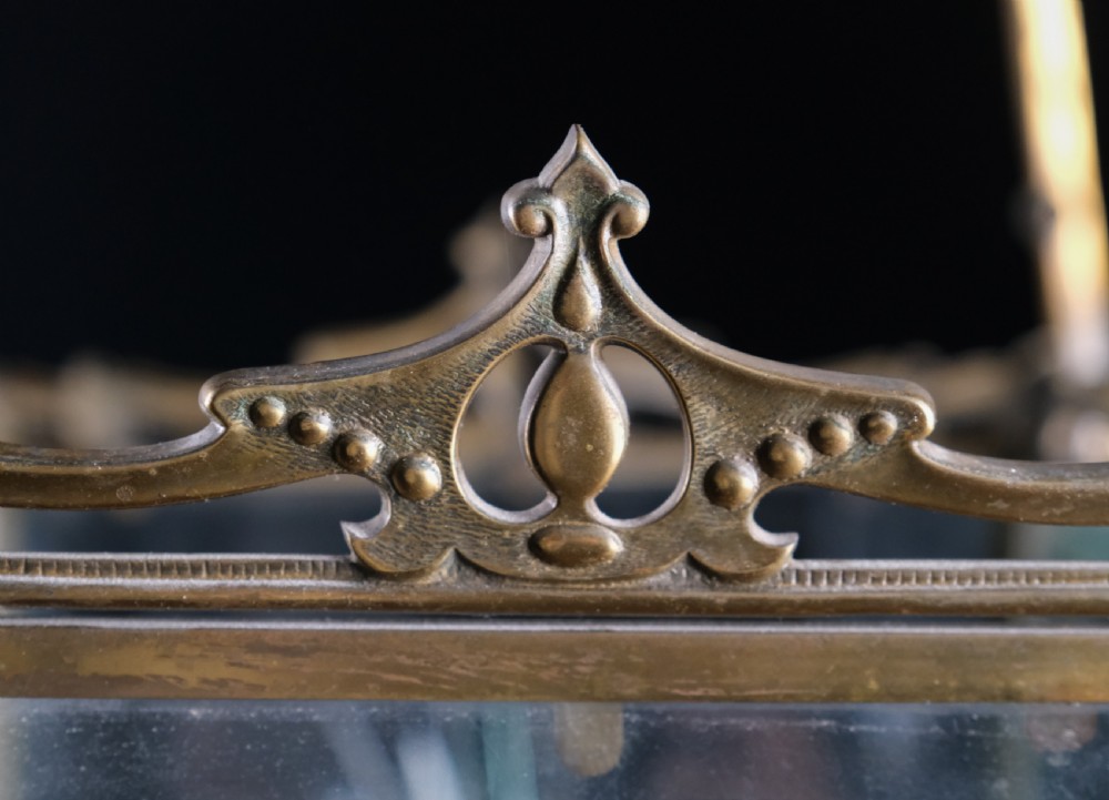An Edwardian brass square-framed hall lantern featuring bevelled glass panels with starburst cuts and scrollwork hanging arms. View VII