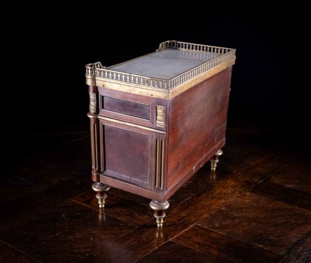 A miniature Louis XVI style mahogany three-drawer commode featuring brass mounts, fluted corner columns, and a gallery top inset with marble. View XIII