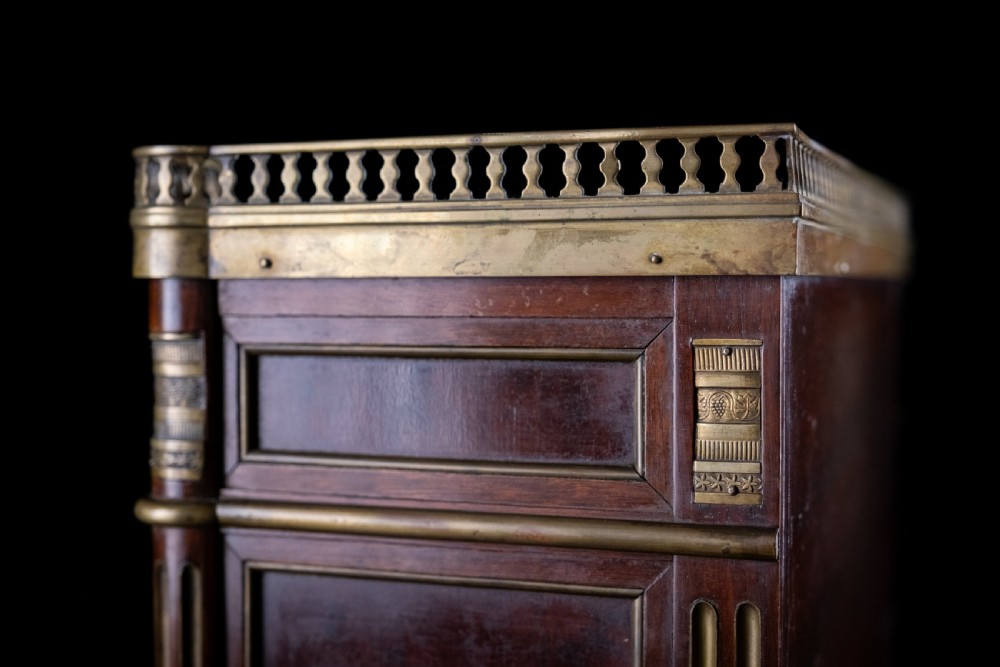 A miniature Louis XVI style mahogany three-drawer commode featuring brass mounts, fluted corner columns, and a gallery top inset with marble. View XIV