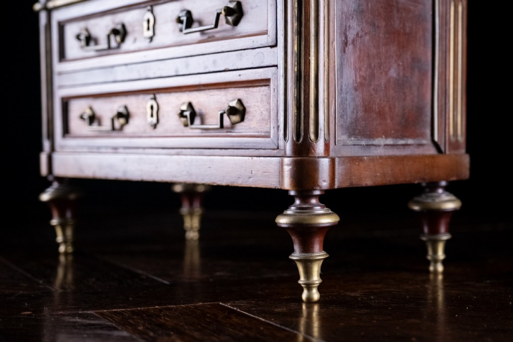 A miniature Louis XVI style mahogany three-drawer commode featuring brass mounts, fluted corner columns, and a gallery top inset with marble. View XVIII