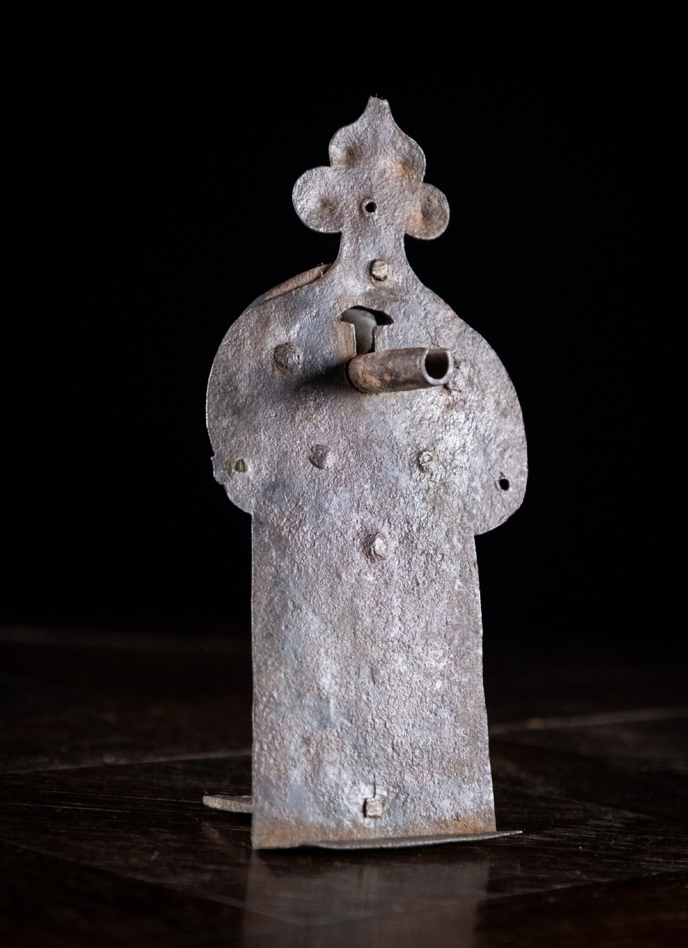 A hand-forged sixteenth-century wrought iron lock plate with a prominent key barrel and trefoil top finial.