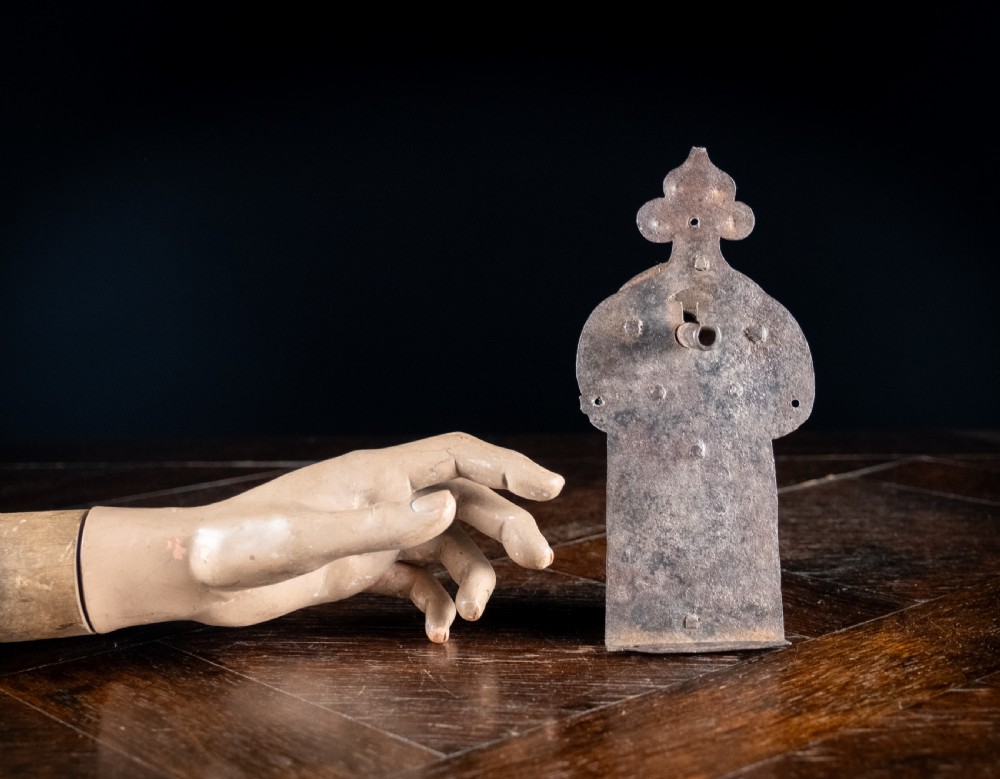 A hand-forged sixteenth-century wrought iron lock plate with a prominent key barrel and trefoil top finial. View X