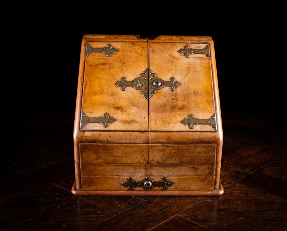 A late nineteenth-century Victorian walnut slope-front stationery cabinet featuring ornate brass strapwork mounts and lock escutcheons. View II