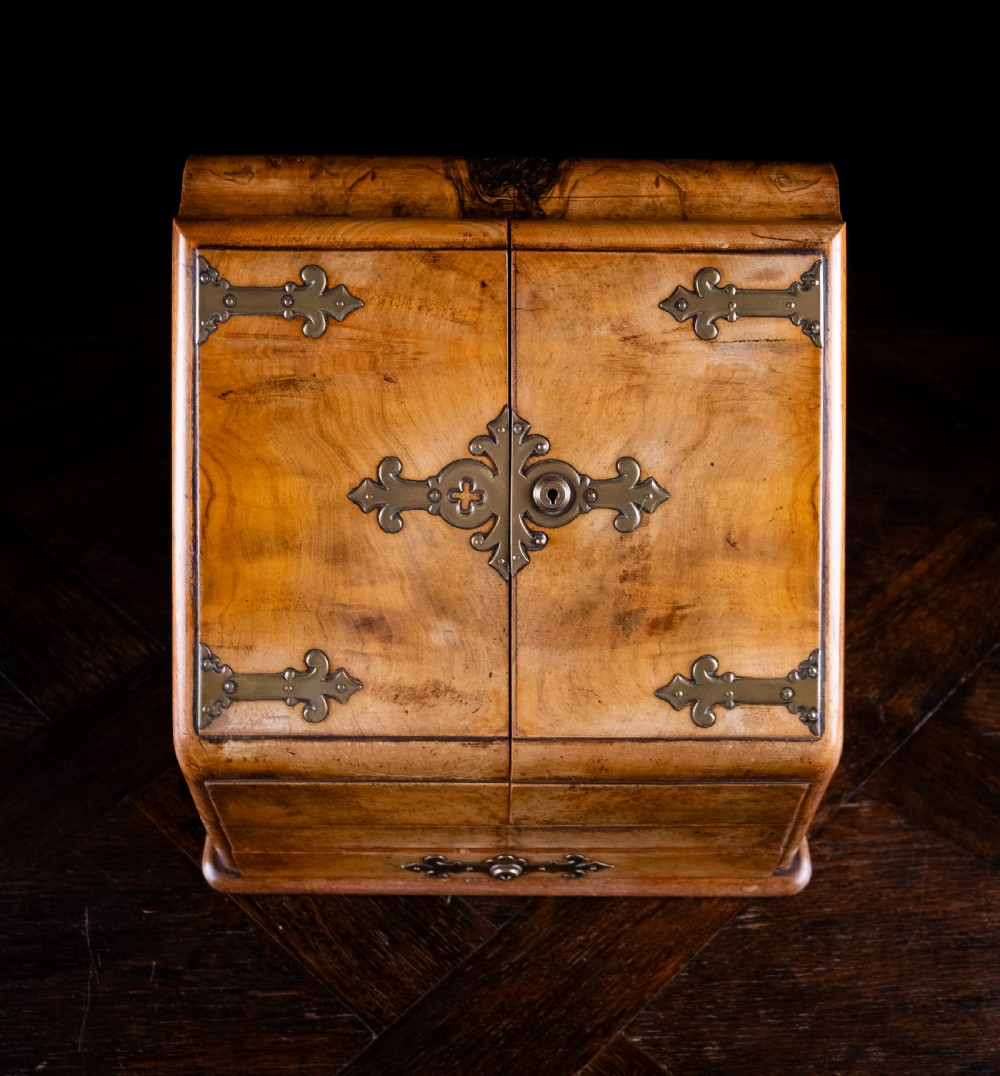 A late nineteenth-century Victorian walnut slope-front stationery cabinet featuring ornate brass strapwork mounts and lock escutcheons. View III