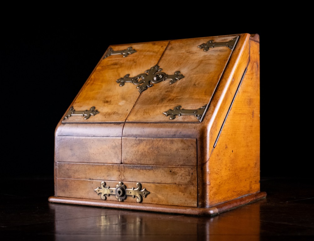 A late nineteenth-century Victorian walnut slope-front stationery cabinet featuring ornate brass strapwork mounts and lock escutcheons. View IV