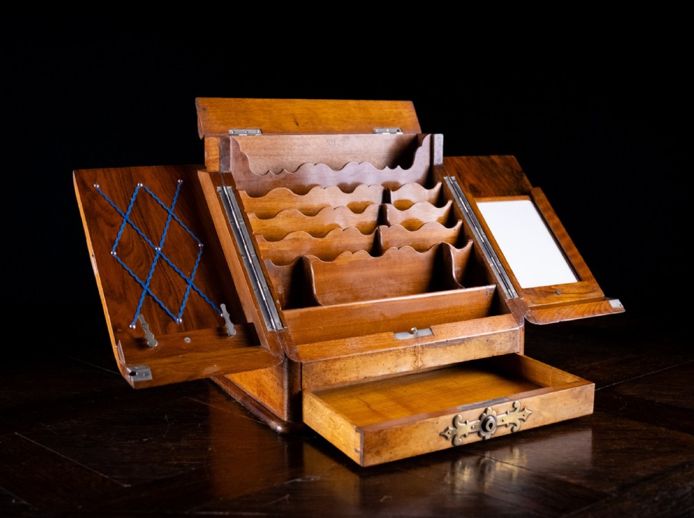 A late nineteenth-century Victorian walnut slope-front stationery cabinet featuring ornate brass strapwork mounts and lock escutcheons. View VII