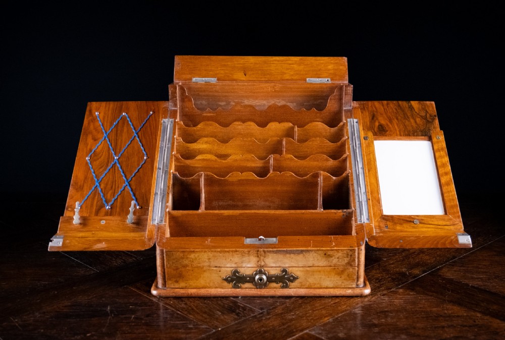 A late nineteenth-century Victorian walnut slope-front stationery cabinet featuring ornate brass strapwork mounts and lock escutcheons. View VIII