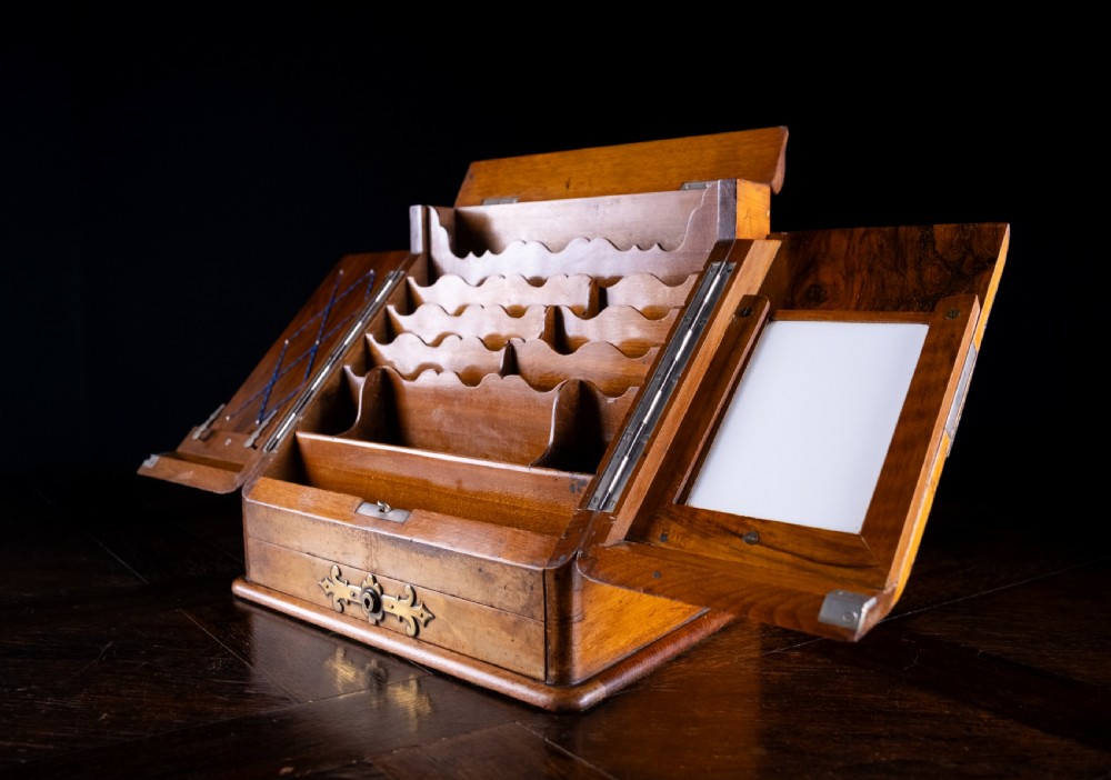 A late nineteenth-century Victorian walnut slope-front stationery cabinet featuring ornate brass strapwork mounts and lock escutcheons. View IX