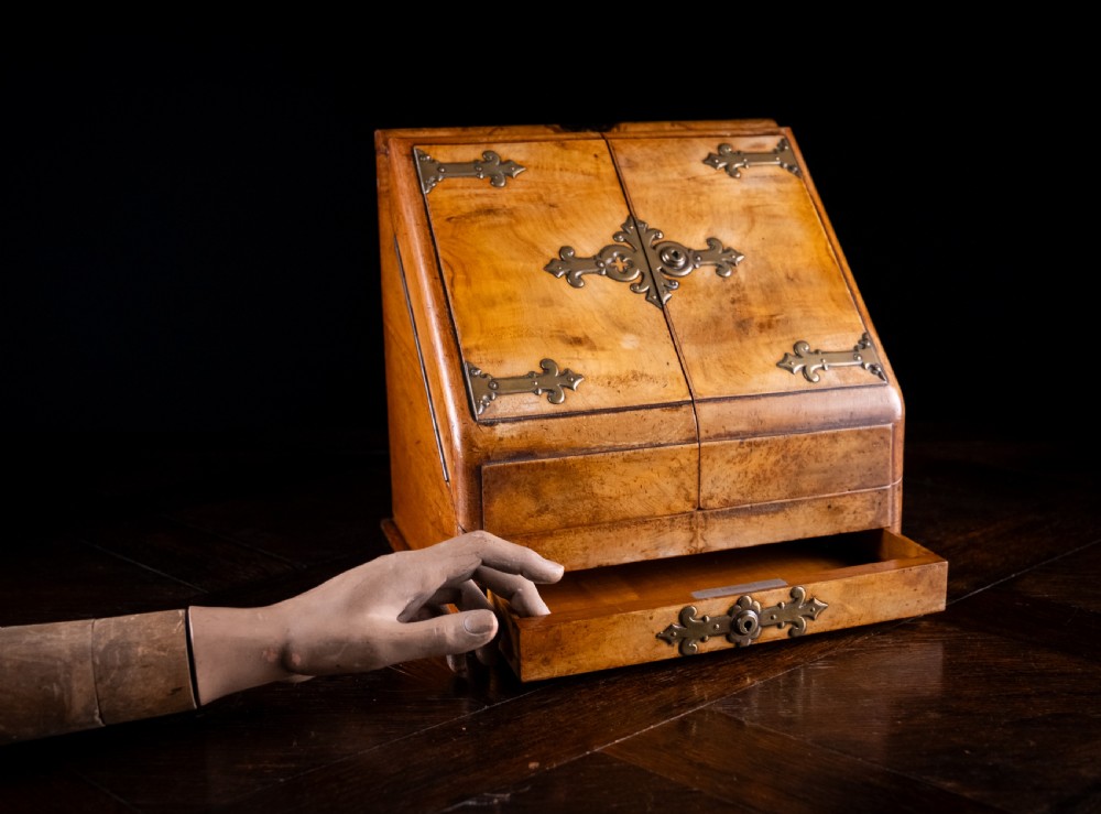 A late nineteenth-century Victorian walnut slope-front stationery cabinet featuring ornate brass strapwork mounts and lock escutcheons. View XII