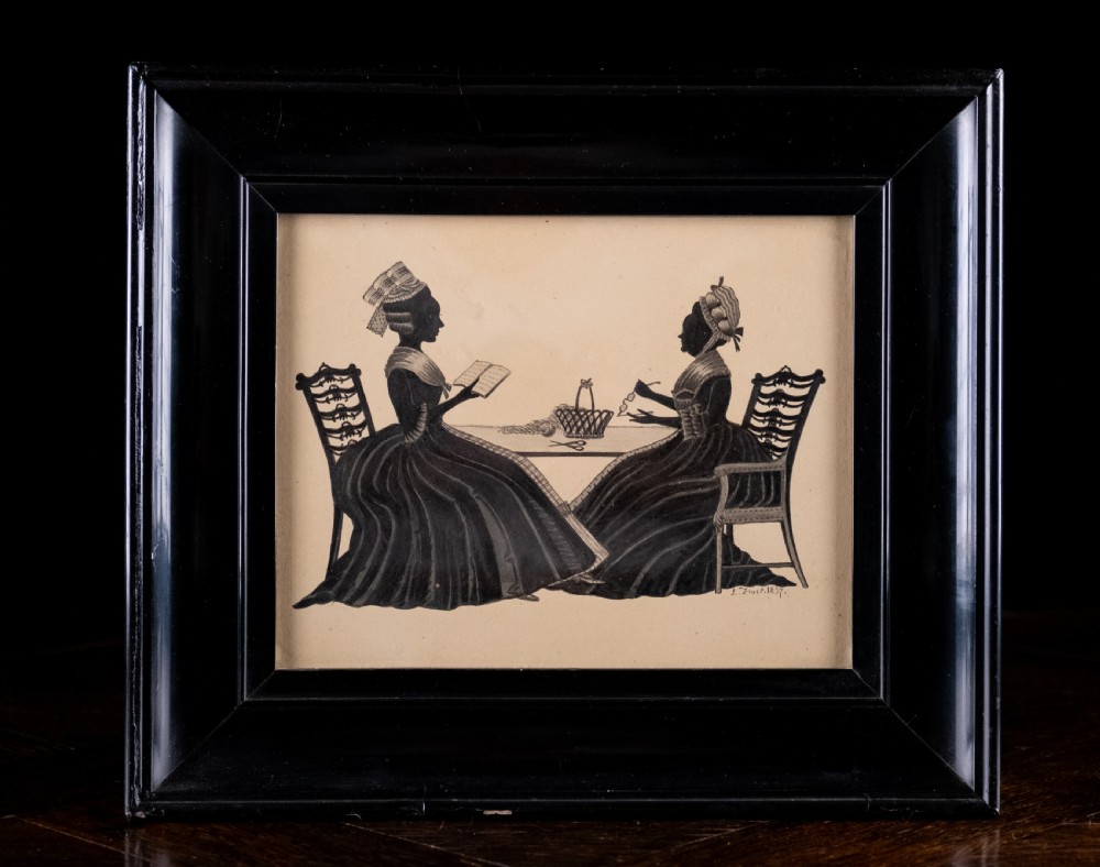 A framed 1837 silhouette artwork featuring two seated ladies in profile facing each other at a table, mounted within a wide black wooden frame.