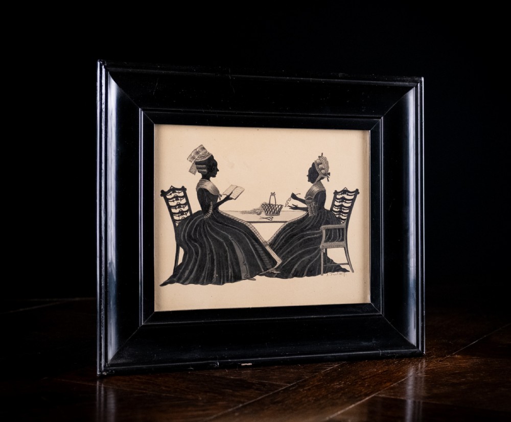 A framed 1837 silhouette artwork featuring two seated ladies in profile facing each other at a table, mounted within a wide black wooden frame. View VI