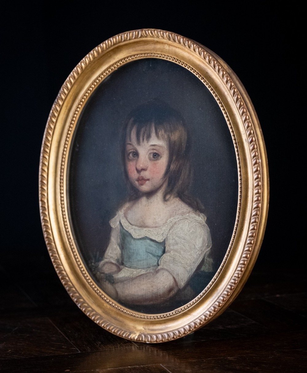 An 18th-century oval portrait painting depicting a young girl with brown hair wearing a blue and white dress within a gilded frame. View IV