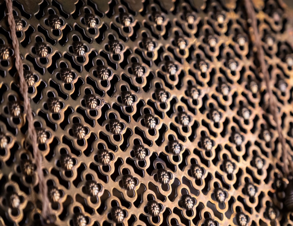 An antique brass folding book rest featuring an intricate pierced fretwork pattern, adjustable easel backing, and weighted page holder cords. View II