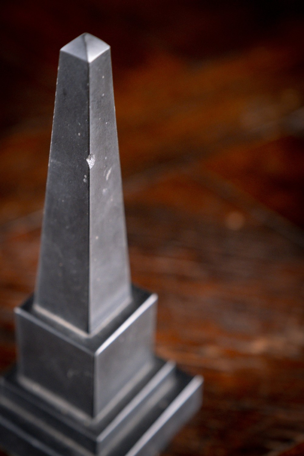 A pair of 19th-century black marble obelisks featuring tapered four-sided shafts set on stepped square plinth bases. View V