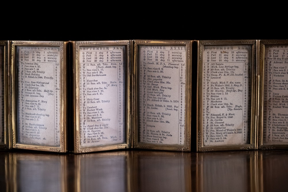 A nineteenth-century six-fold miniature brass frame holding printed paper London almanac sheets dated 1878. View II