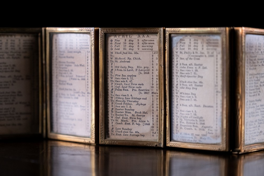 A nineteenth-century six-fold miniature brass frame holding printed paper London almanac sheets dated 1878. View III